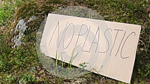 cardboard sign with the inscription no plastic in the forest