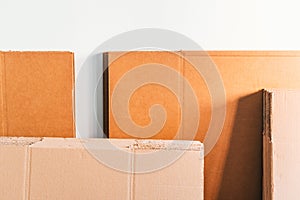 Cardboards stacked on a white wall ready to form boxes to transport household goods