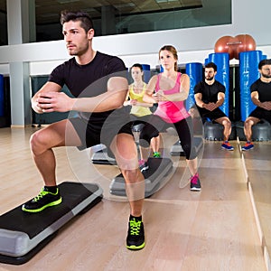 Cardio step dance squat group at fitness gym