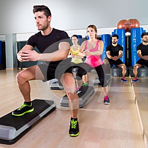 Cardio step dance squat group at fitness gym