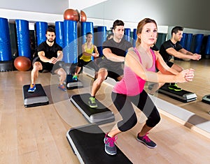 Cardio step dance squat group at fitness gym