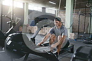 Cardio Training. Sports Man Exercising On Rowing Machine At Gym