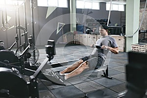 Cardio Training. Sports Man Exercising On Rowing Machine At Gym