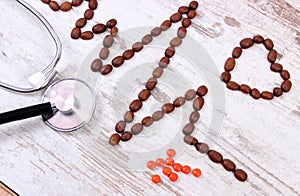Cardiogram line of coffee grains, stethoscope and supplement pills, medicine and healthcare concept