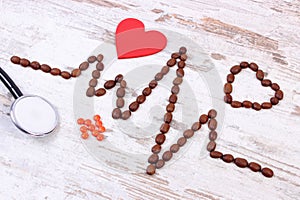Cardiogram line of coffee grains, stethoscope and supplement pills, medicine and healthcare concept
