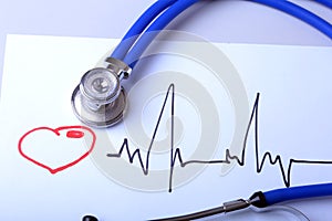 Cardiogram with medical stethoscope and doctor coat on table