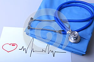 Cardiogram with medical stethoscope and doctor coat on table