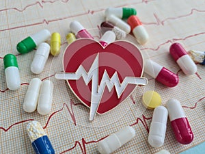 Cardiogram with red heart pills and cardiogram. Treatment of cardiovascular disea photo