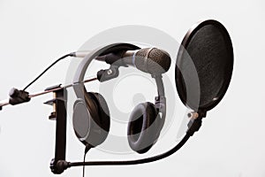 Cardioid condenser microphone, headphones and pop filter on a gray background. Home recording Studio