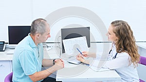 A cardiologist analyzes the results of an electrocardiogram of an elderly man& x27;s heart during a consultation. Medical