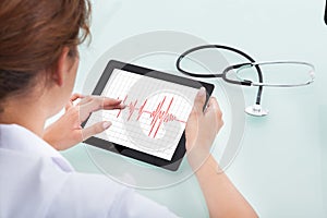 Cardiologist Analyzing Heartbeat On Digital Tablet