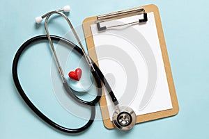 Cardiologist day. Stethoscope, flowers and heart shape, space for text on blue background