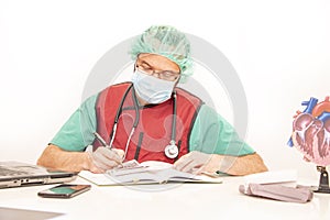 Cardiologist doctor working in his office wearing an operating theatre suit and lead x-ray protective equipment, white background