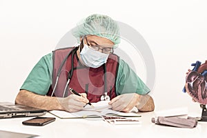 Cardiologist doctor working in his office wearing an operating theatre suit and lead x-ray protective equipment, white background