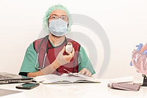 Cardiologist doctor working in his office wearing an operating theatre suit and lead x-ray protective equipment, white background