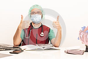 Cardiologist doctor working in his office wearing an operating theatre suit and lead x-ray protective equipment, white background