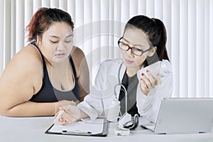 Cardiologist doctor writing prescriptions to her patient