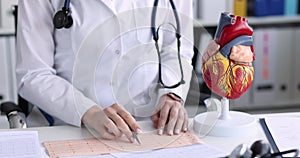 Cardiologist examines electrocardiogram of patient with heart disease