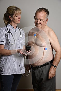 Cardiologist installs a ECG heart monitor onto a patient