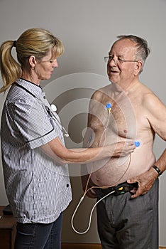 Cardiologist installs a ECG heart monitor onto a patient