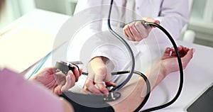 Cardiologist measures patient blood pressure with tonometer