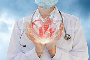 Cardiologist shows a heart in hands . photo