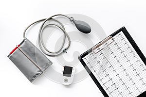 Cardiologist work desk with pulsimeter and cardiogram on white background top view