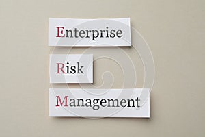 Cards with abbreviation ERM Enterprise Risk Management on beige background, flat lay