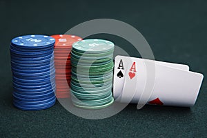 Cards aces and chips on green casino game table.