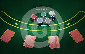 Cards and chips for poker on green table, top view