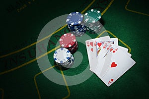 Cards and chips for poker on green table, top view