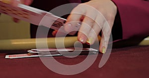 Cards and chips on the table in a casino. Close-up of hands.. Close-up of hands playing poker with chips on red table.