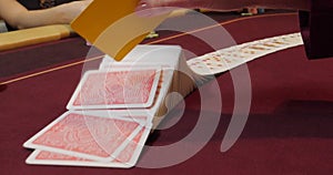 Cards and chips on the table in a casino. Close-up of hands.. Close-up of hands playing poker with chips on red table.