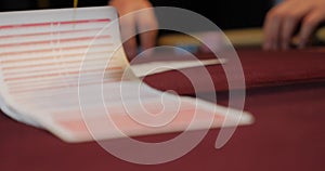 Cards and chips on the table in a casino. Close-up of hands.. Close-up of hands playing poker with chips on red table.