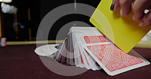 Cards and chips on the table in a casino. Close-up of hands.. Close-up of hands playing poker with chips on red table.