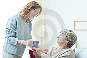 Care assistant helping elderly lady