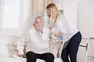 Care assistant helping senior man