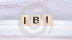 Care concept. IBI word on wooden cubes on an abstract background photo