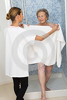 Care giver or nurse assisting elderly woman for shower
