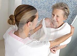 Care giver or nurse assisting elderly woman for shower