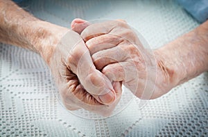 Care is at home of elderly. Old people holding hands.