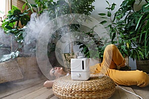 Care for houseplants: using air humidifier at home to keep humidity and indoor plants health concept