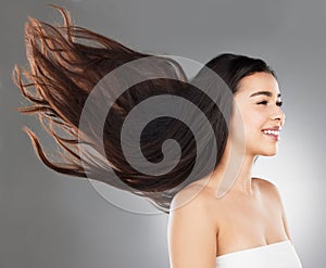 Care for more than just the surface. Studio shot of a beautiful young woman with flowing hair against a grey background.