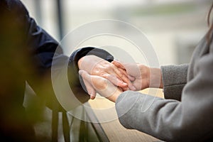 Close-up of young female hands holding senior woman hands