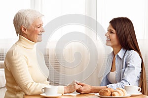 Care and support. Daughter holding mother`s hand