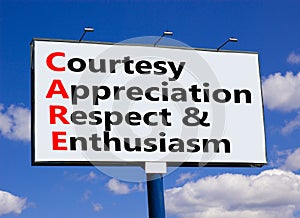 CARE symbol. Concept words CARE courtesy appreciation respect and enthusiasm on big billboard against beautiful blue sky. Business