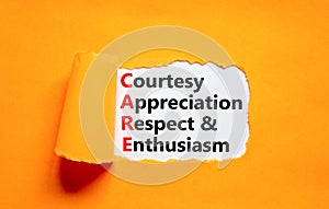 CARE symbol. Concept words CARE courtesy appreciation respect and enthusiasm on white paper on beautiful orange background.