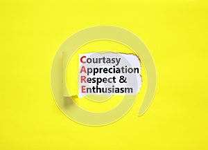 CARE symbol. Concept words CARE courtesy appreciation respect and enthusiasm on white paper on beautiful yellow background.