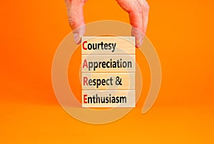 CARE symbol. Concept words CARE courtesy appreciation respect and enthusiasm on wooden block on beautiful orange background.