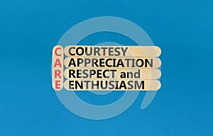 CARE symbol. Concept words CARE courtesy appreciation respect and enthusiasm on wooden stick on beautiful blue background.